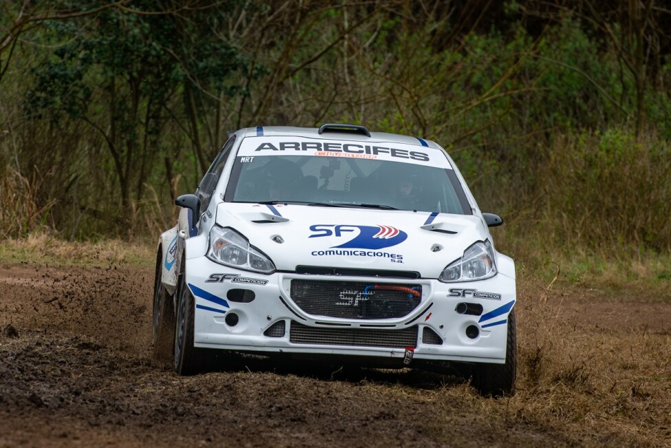 Auto de rally compitiendo en un camino de tierra.