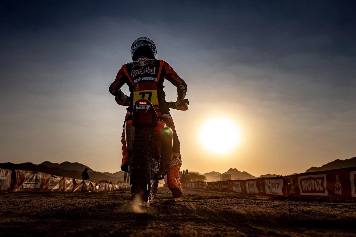 Una motocicleta en el Dakar con el sol de fondo