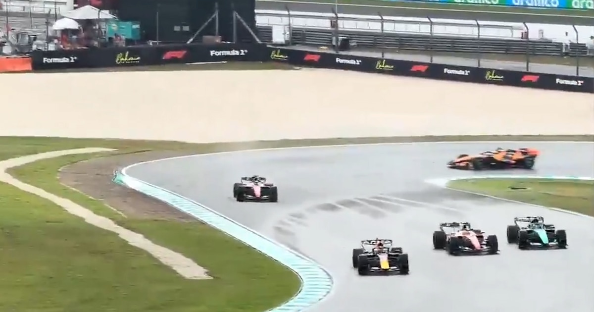 Monoplazas de Fórmula 1 circulando a baja velocidad bajo la lluvia en el circuito de Sepang.