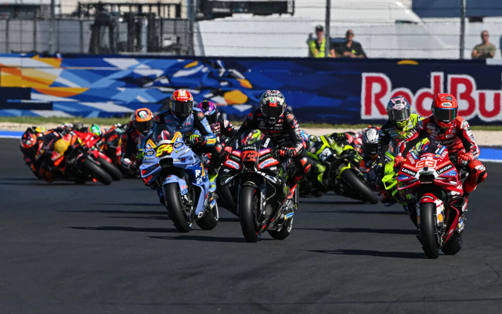 Pilotos de MotoGP en plena competencia durante una largada.