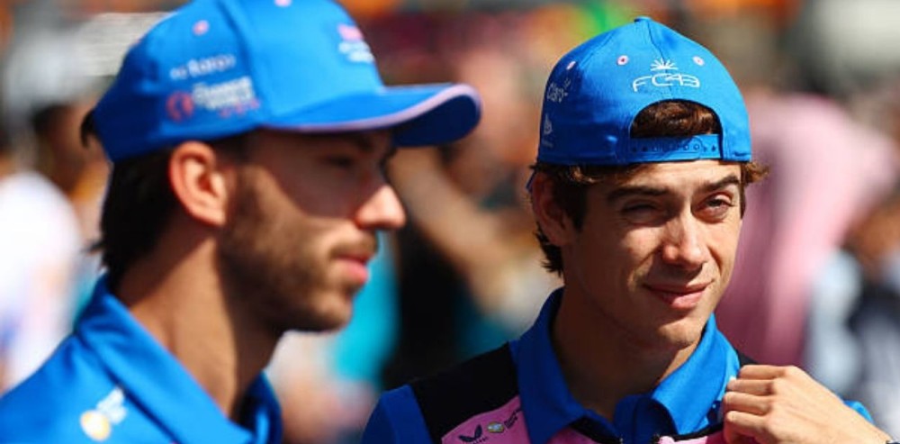 Franco Colapinto y Pierre Gasly conversando en el paddock de la Fórmula 1 con indumentaria oficial de Alpine.