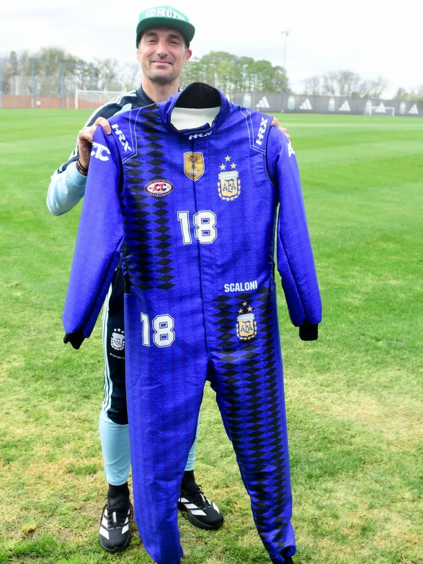 Lionel Scaloni posa sonriente junto al buzo de competición personalizado con los colores de la Selección Argentina y el número 18, obsequiado por la ACTC en el predio de Ezeiza.