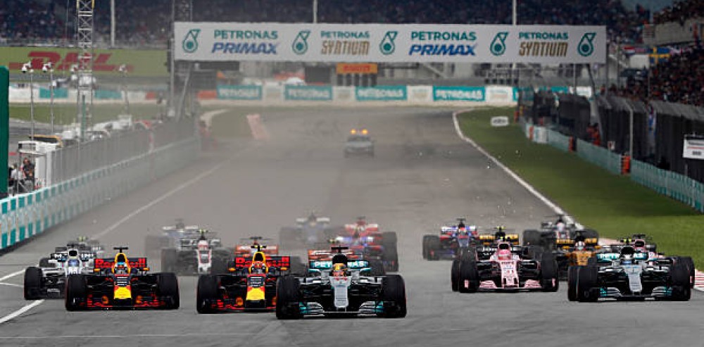 Monoplazas de Fórmula 1 acelerando en la recta principal del Circuito Internacional de Sepang durante una competencia.