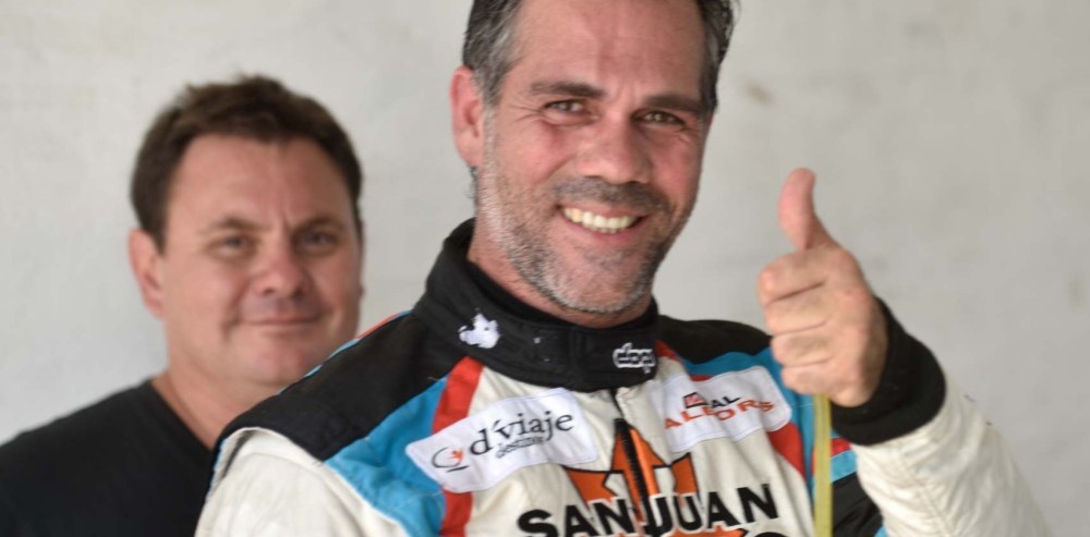 Fabián Flaqué sonriendo junto a un integrante de su equipo con indumentaria de competición.
